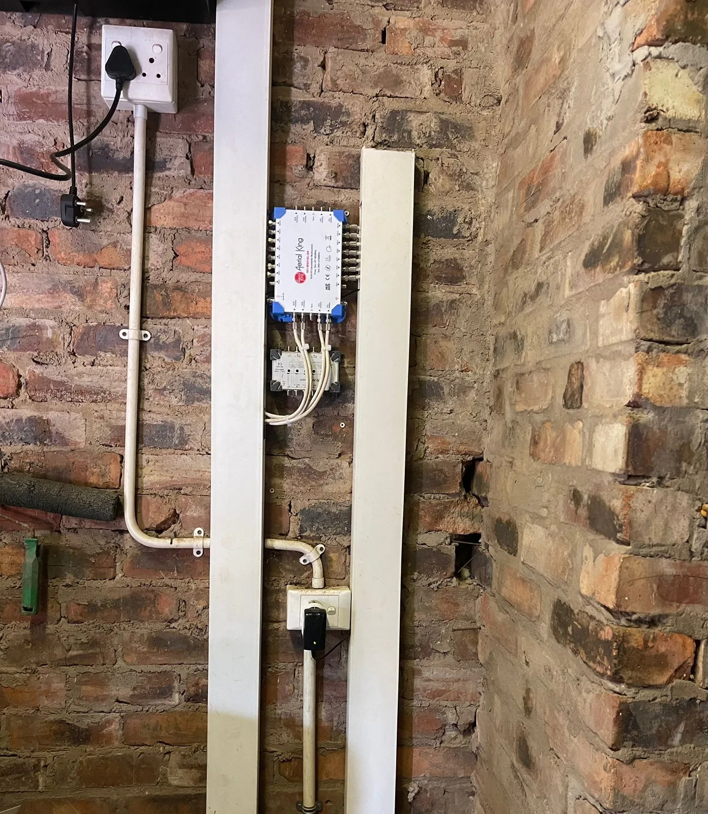Neatly terminated DSTV multiswitch and cabling on a face-brick exterior wall