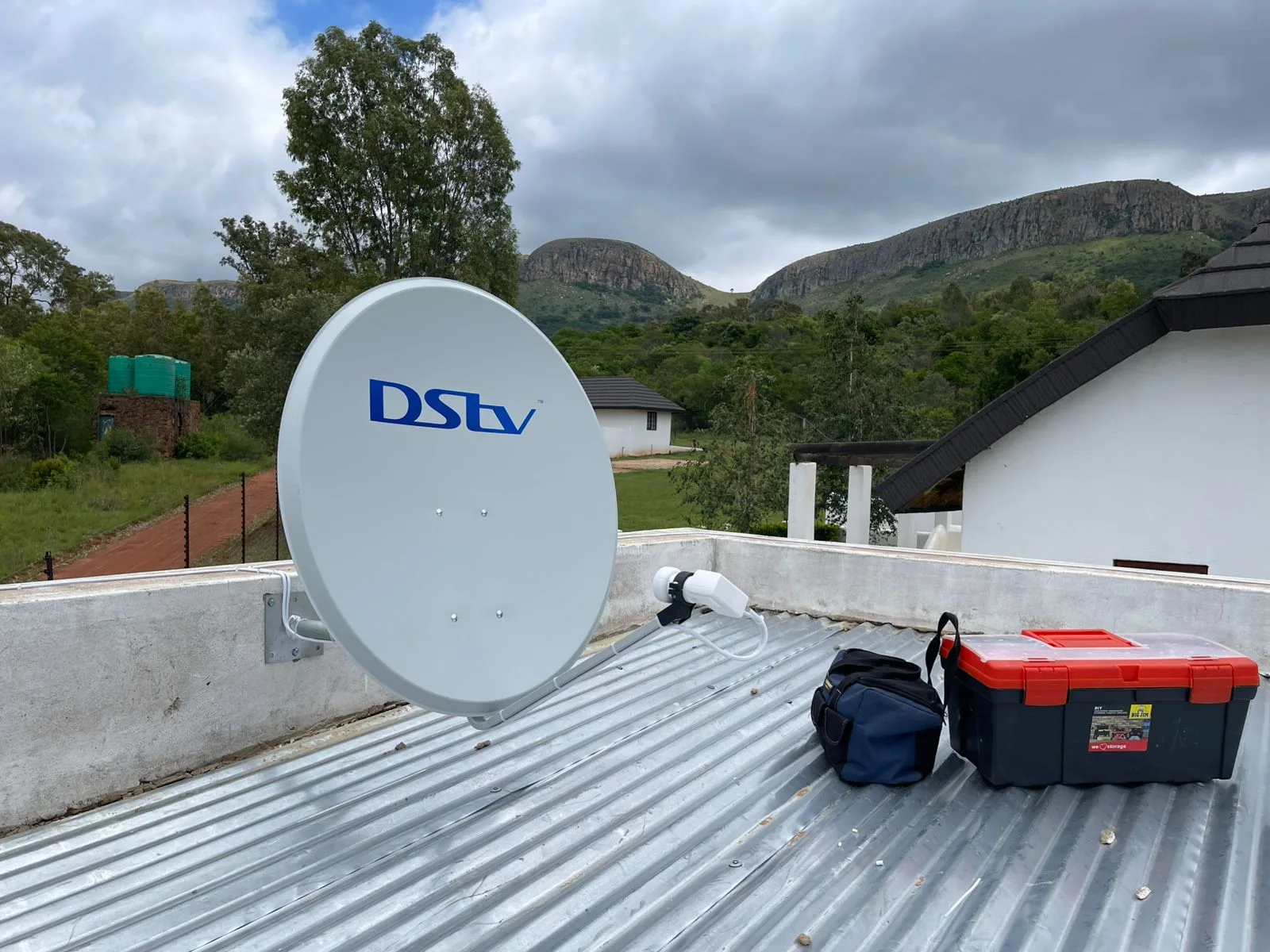 DSTV satellite dish on a metal roof with the Pretoria mountains behind
